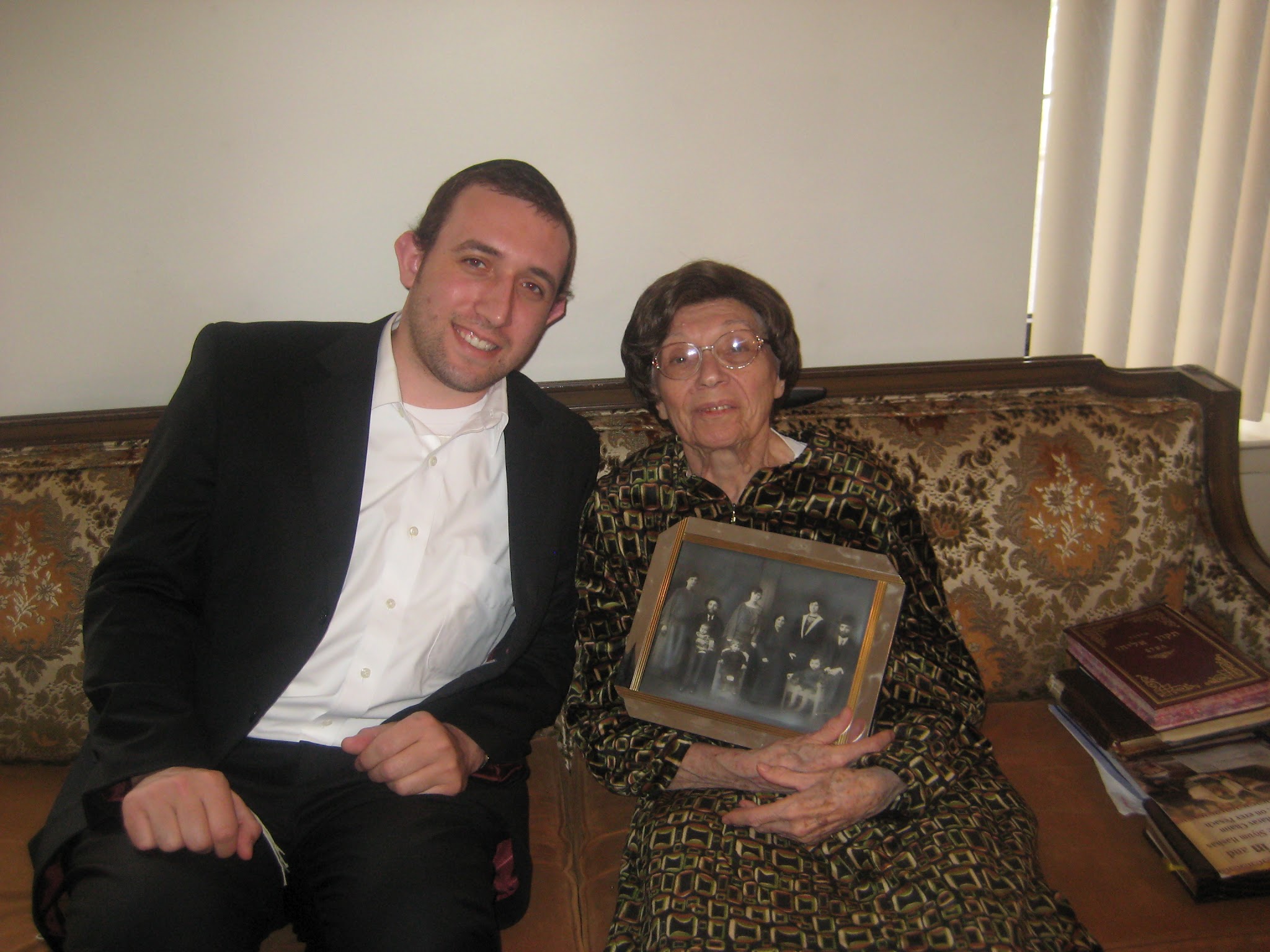 Bobby (Irene Weisz Feig) showing her grandson Yitz the famous 1922 Apagy photograph: her parents Lipot and Regina, her brother Imre, her grandparents, and the Feldmans from across the street.